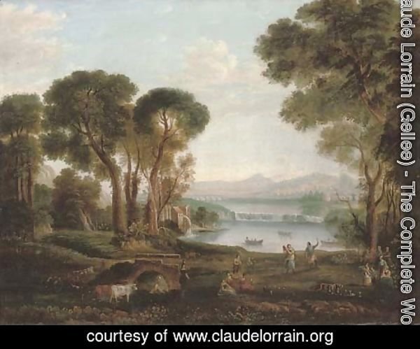 An Italianate river landscape with figures dancing and making music on a bank, a town beyond